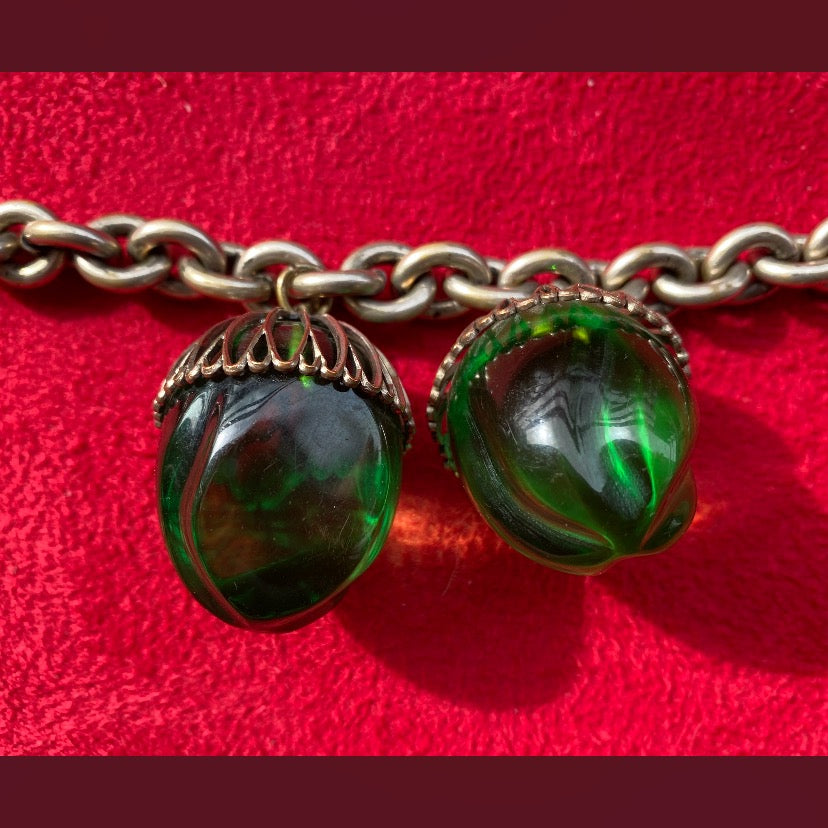 Very rare, vintage white metal bracelet with two green lucite acorn-shaped pendants.