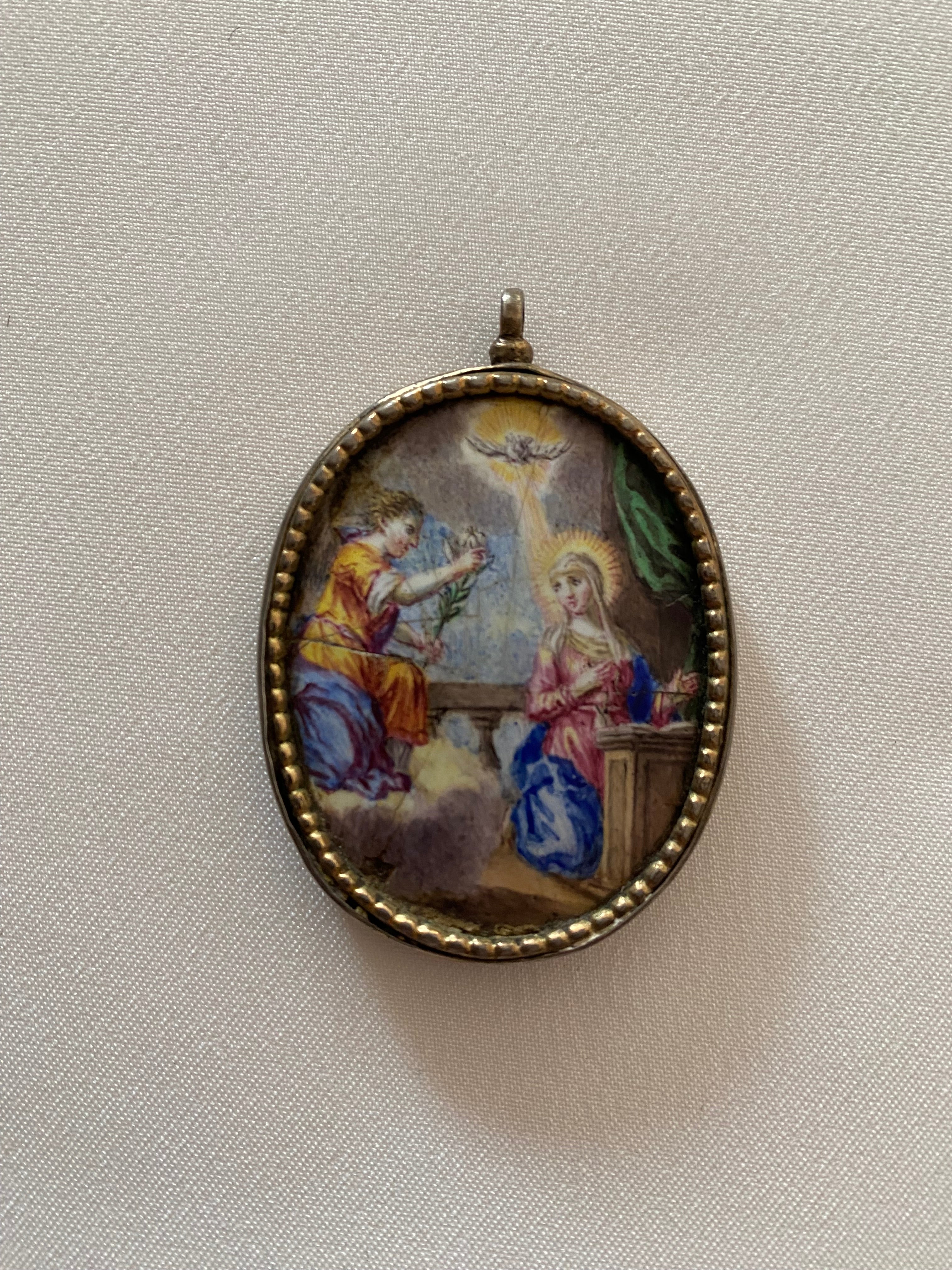 Antique silver medallion pendant with the Annunciation of the Angel Gabriel to the Blessed Virgin Mary.