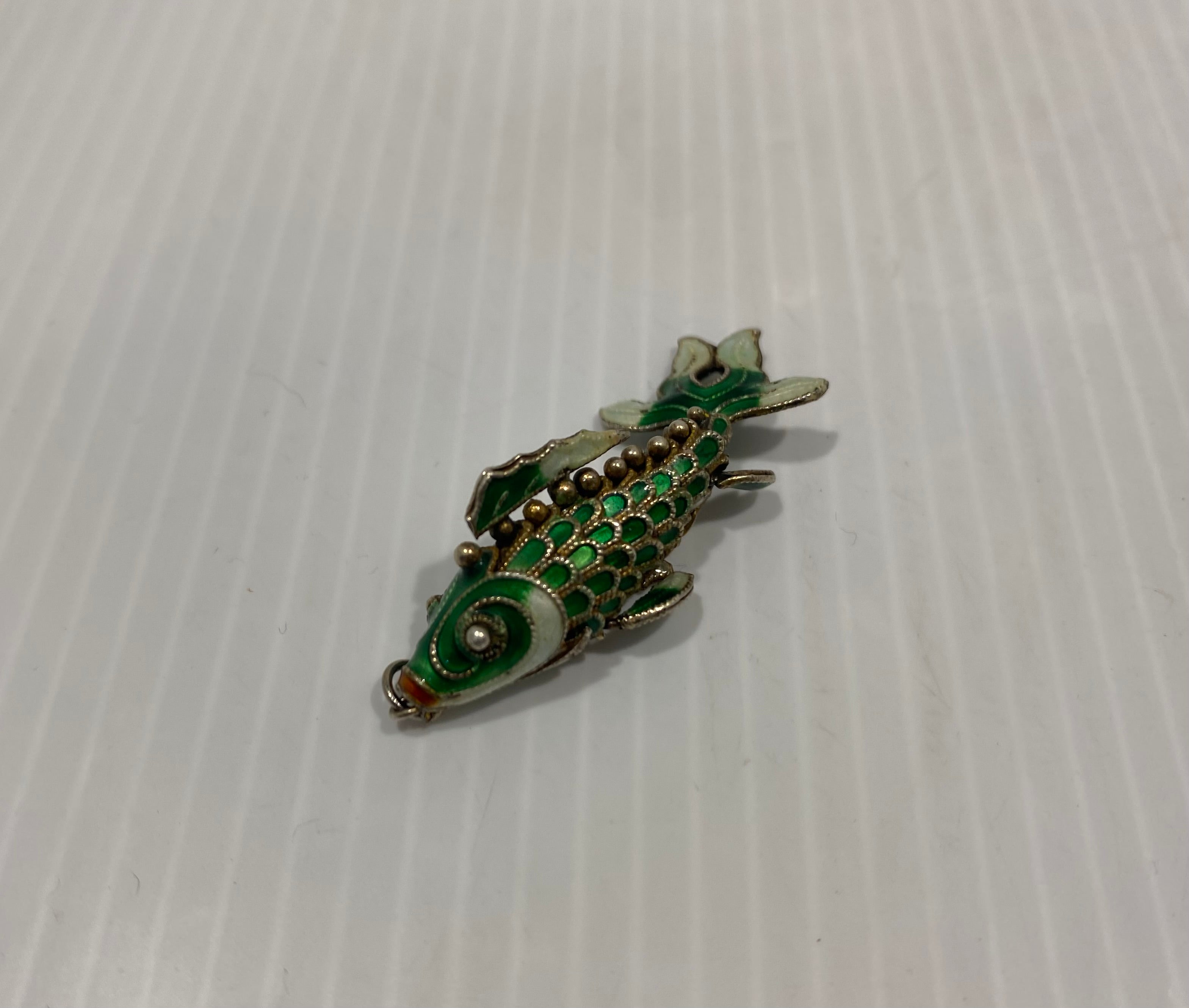 Beautiful, green, vintage articulated enamel fish pendant.