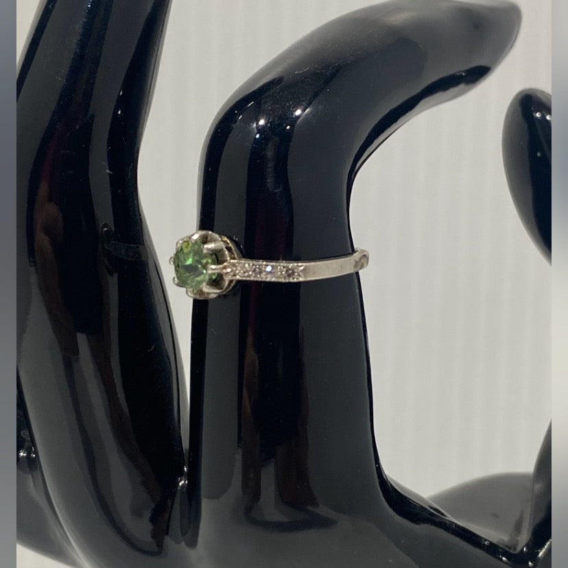 Antique, French 18k white gold ring decorated along the shoulders with diamonds and centered by a brilliant cut Peridot