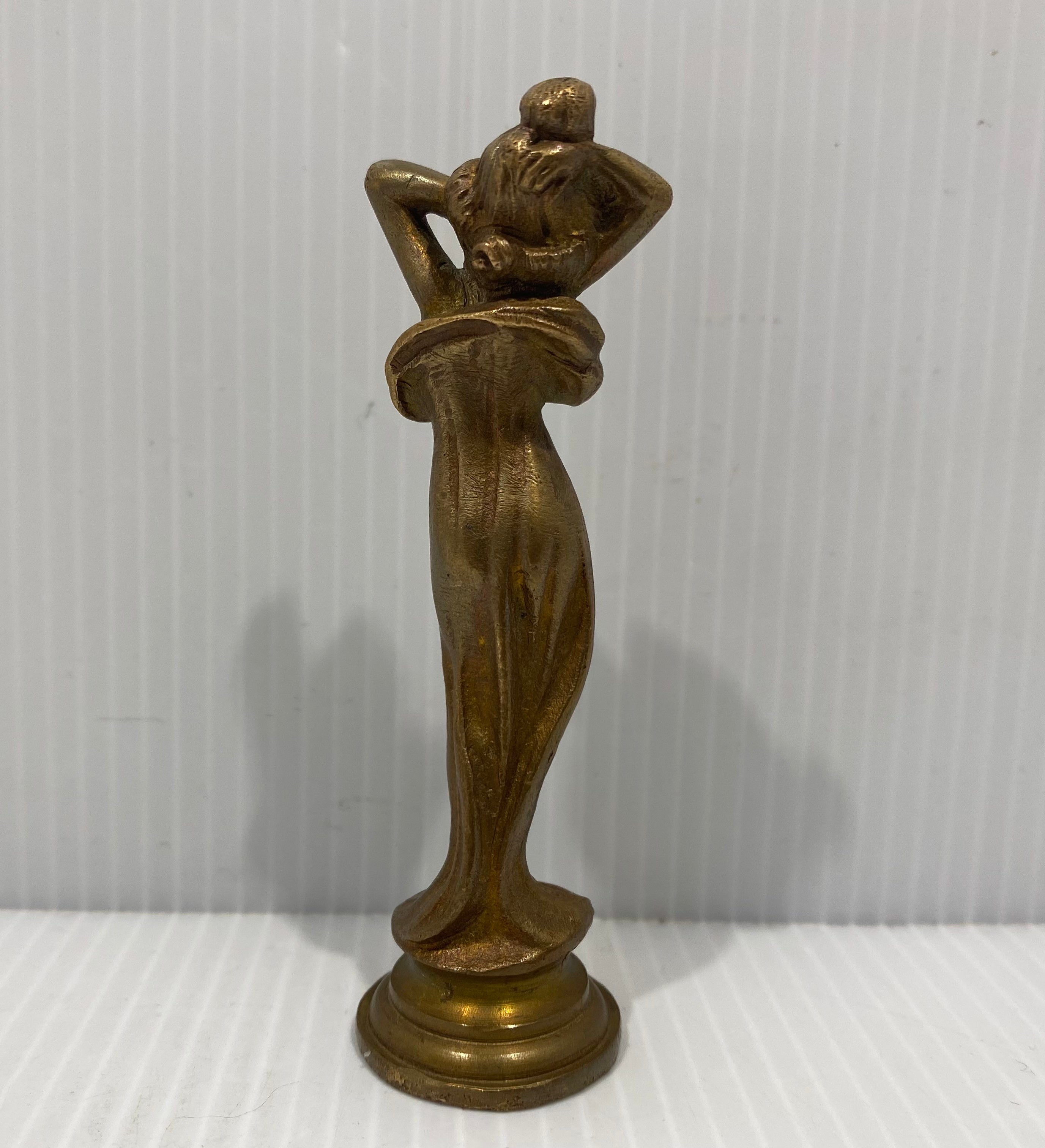 A lovely Art Nouveau bronze wax seal stamp of a woman figure, with long hair standing in a gown atop a beveled round base.