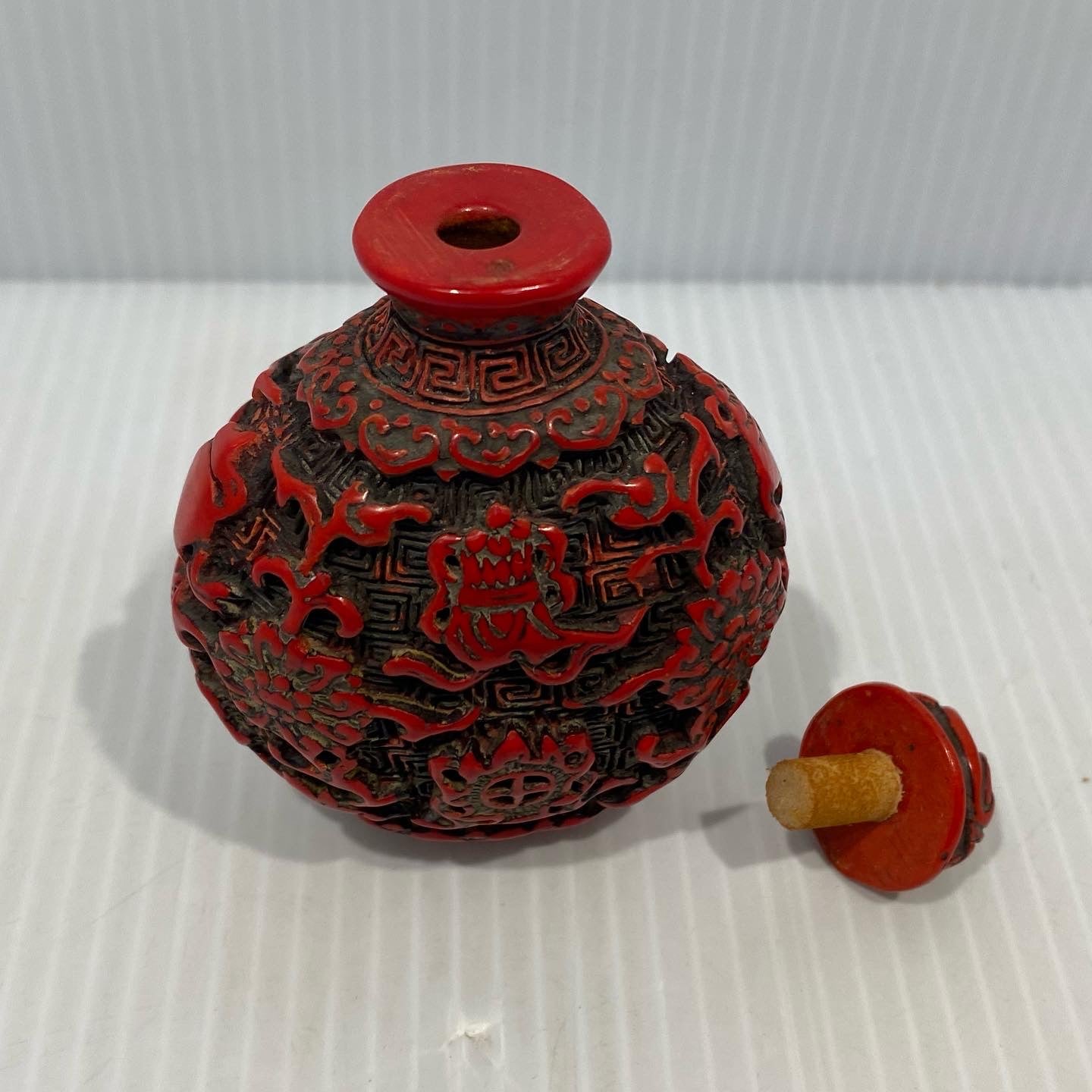 Antique Chinese Cinnabar lacquer snuff bottle, carved  with Buddha Symbols. Original stopper. Early 20th century.