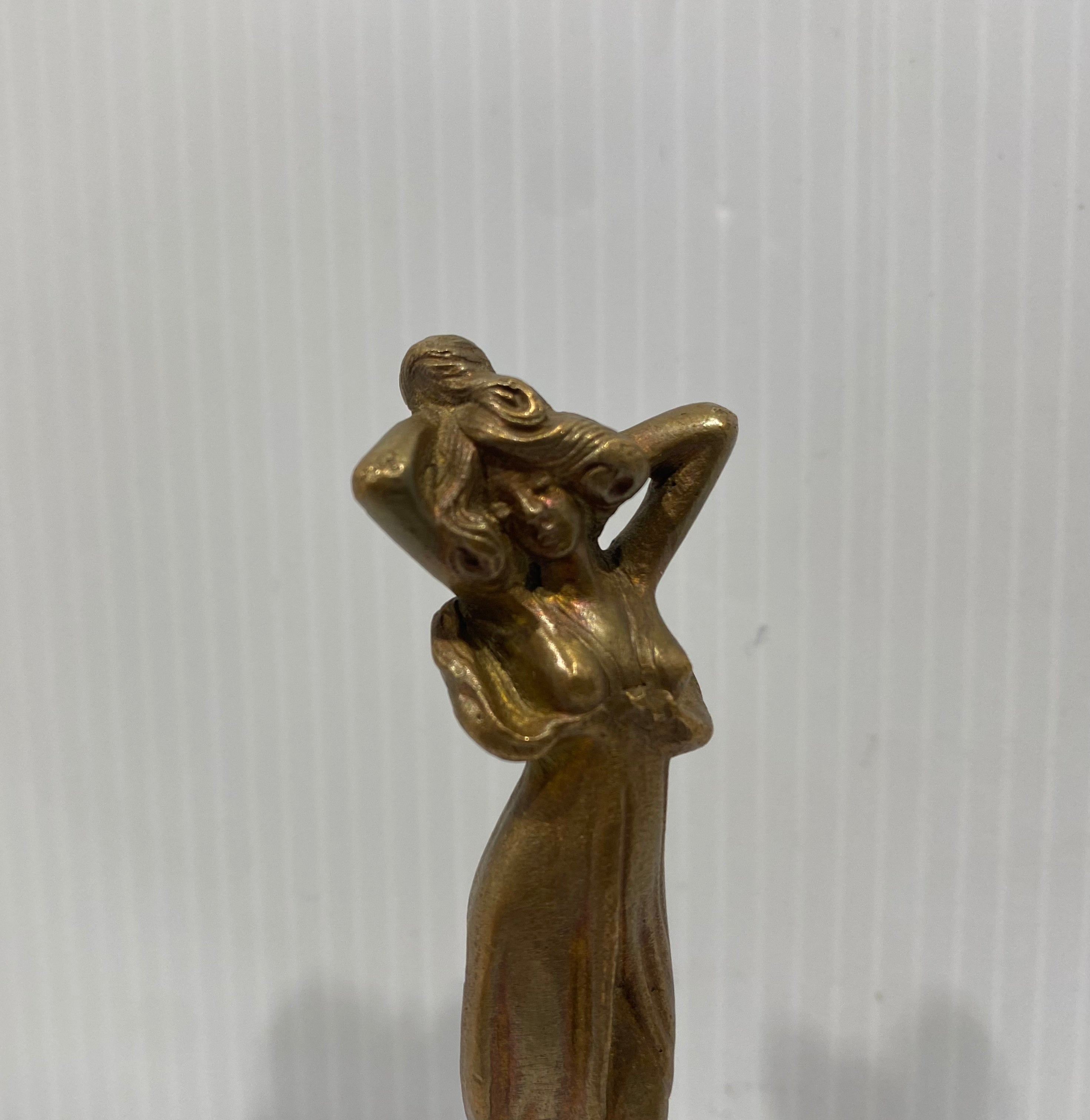 A lovely Art Nouveau bronze wax seal stamp of a woman figure, with long hair standing in a gown atop a beveled round base.