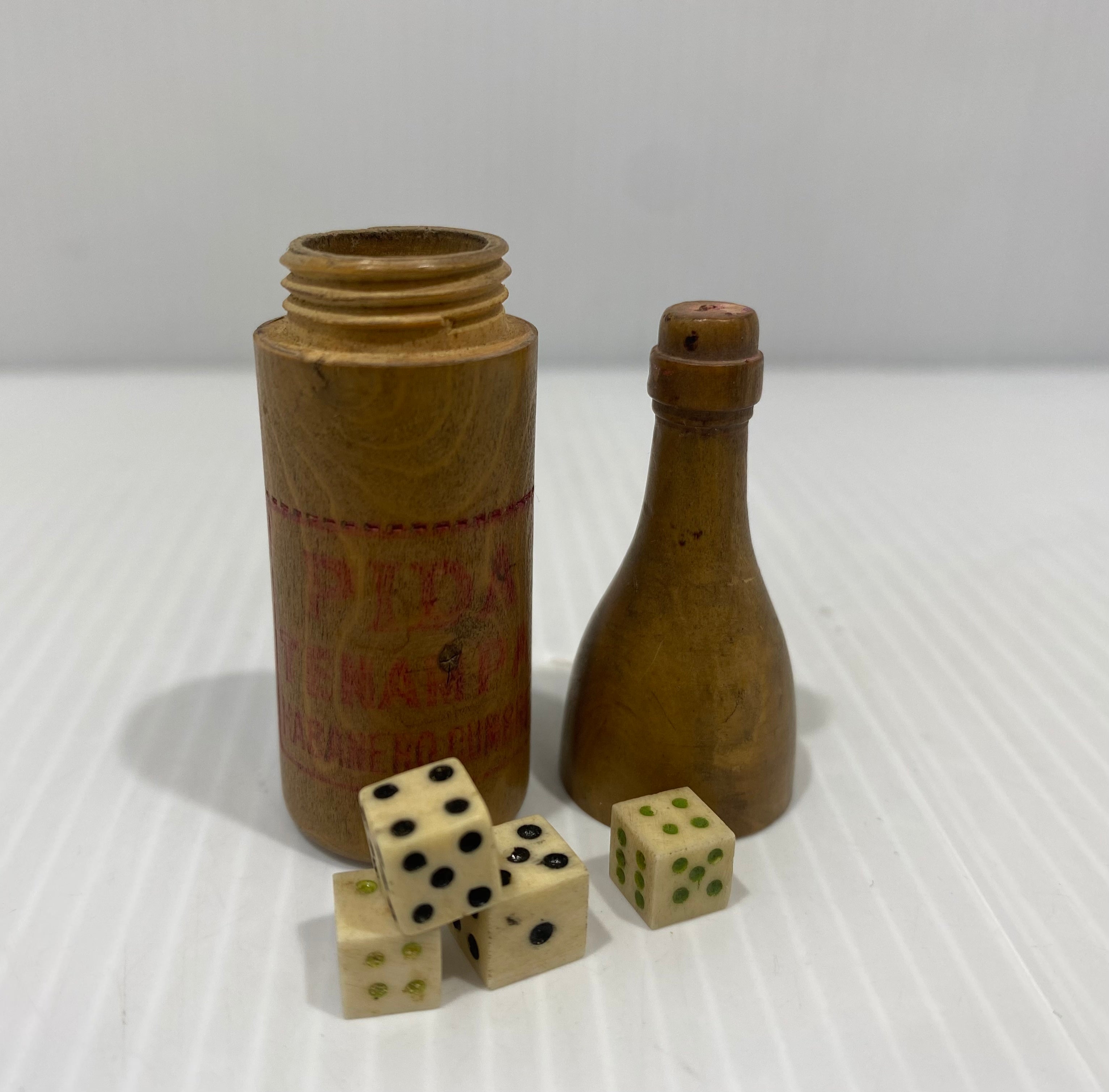 Miniature Wooden Bottle Shaped Box Containing four Small Bone Dice.